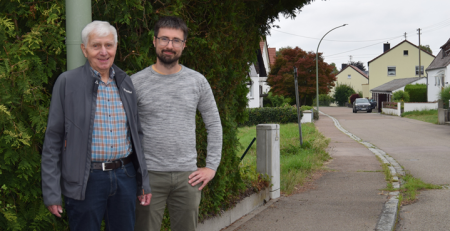 Herr Wieland und Herr Nuber von der Baugenossenschaft Wertingen vor einem Strassenschild